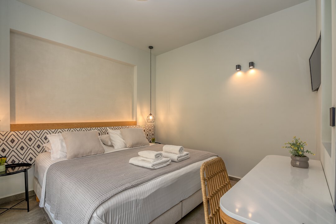 Tranquil bedroom with waffle bedding, bedside tables, and warm ambient lighting at Nusa Gramvousa villa, Crete