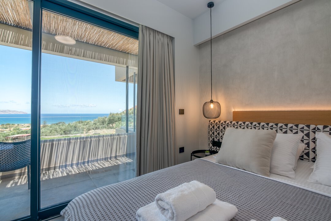 Elegant bedroom suite with modern amenities and coastal views at Nusa Falassarna, Crete
