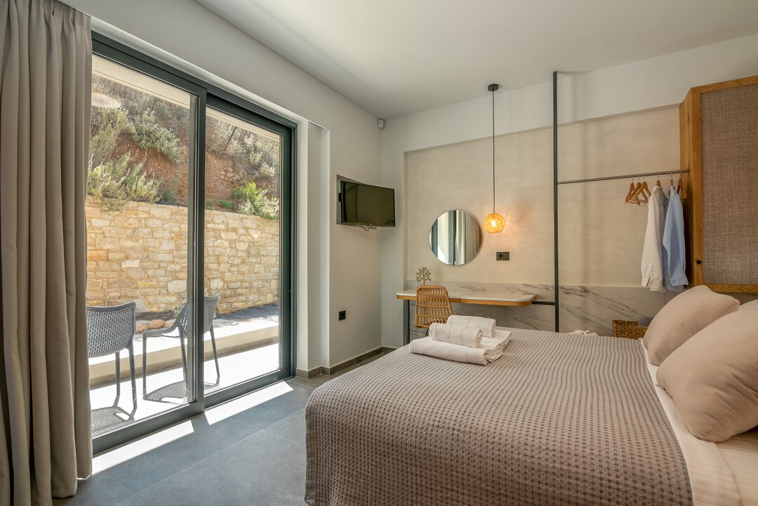 Sun-drenched bedroom with large windows and bright atmosphere at Nusa Balos villa, Crete