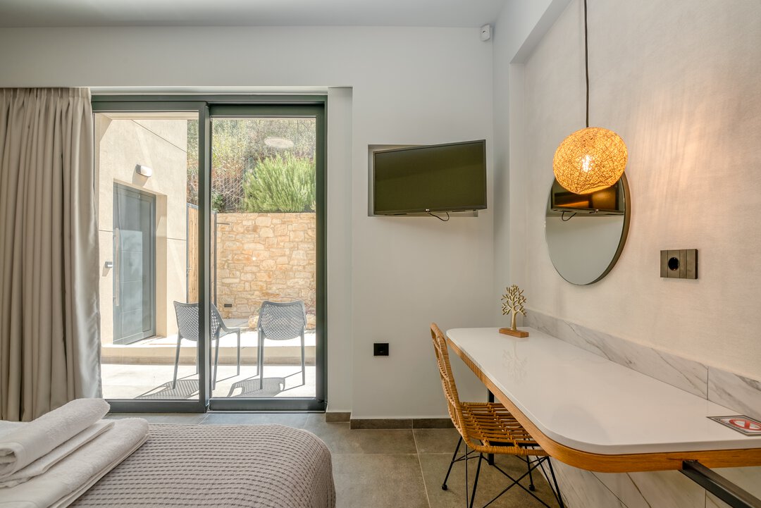 Elegant double room with upholstered headboard, bedside tables, and warm lighting at Nusa Balos villa, Crete