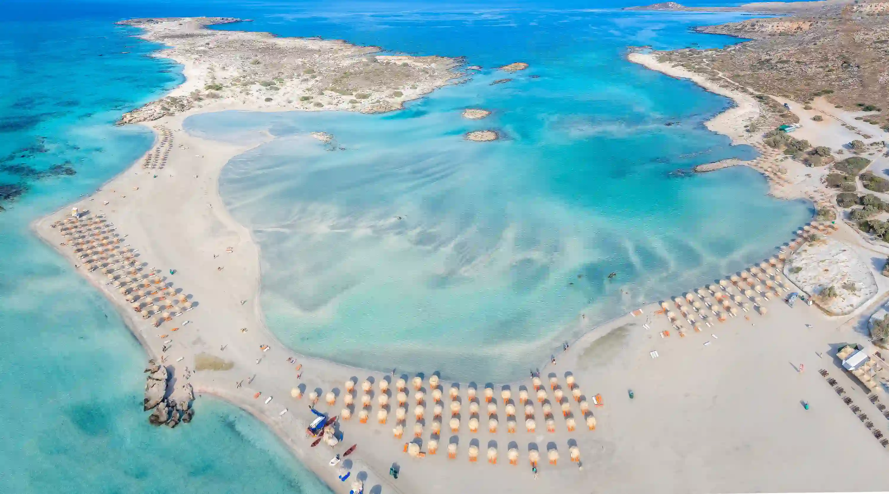 Aerial view of Elafonisi Beach with crystal clear turquoise waters and pink-tinged sand, Crete